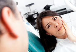 woman holding jaw in pain needs root canal Rockaway, NJ & East Hanover, NJ